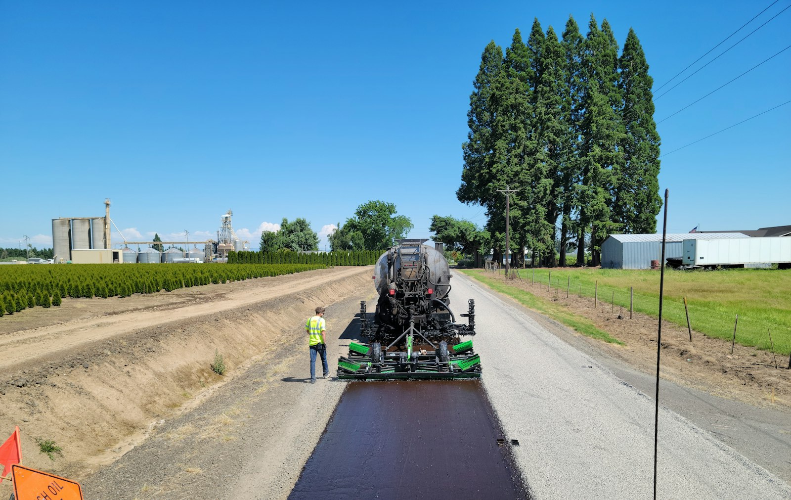 A Landscape Pavers crew laying a fresh asphalt road surface across a rural Lowcountry site